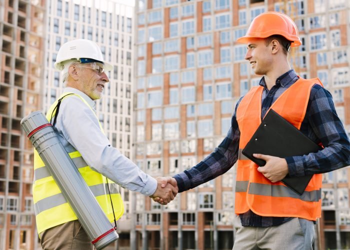 side-view-men-with-safety-vests-shaking-hands